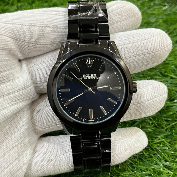 Black watch held in a white glove on green grass