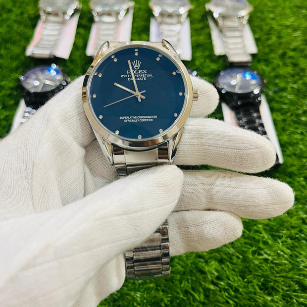 Rolex watch with blue face held by a gloved hand on a grass-like background