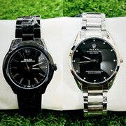 Two Rolex watches, one black and one silver, on a white surface with grass in the background.